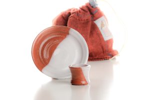 The set includes a cup, a paten, and a felt bag for transport and storage