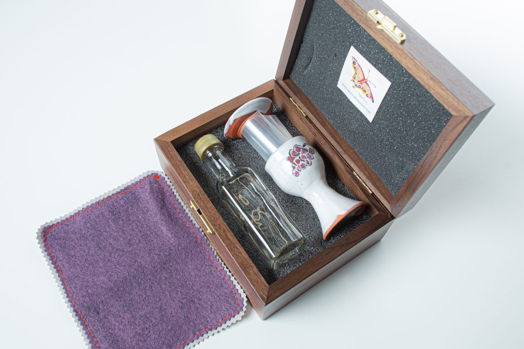 Walnut box (made in USA), custom made to fit the set, with hard foam on the inside bottom of the box, which is carved to hold the set. Soft foam lines the lid and supports the plate to cushion the ceramics for travel.